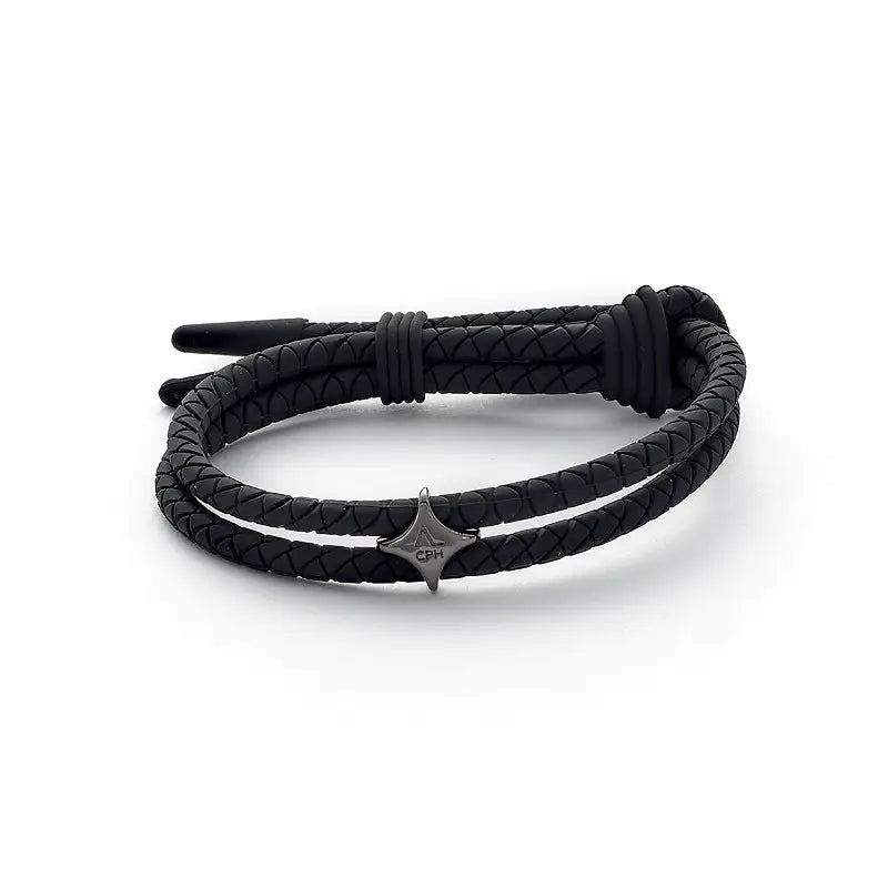 Sort armbånd fra Alexander Lynggaard. Armbåndet er i et sort silikon med en charm i forgylt sølv. Armbåndet er justerbart.